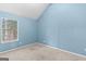 Serene blue bedroom featuring plush carpeting and a window overlooking a peaceful landscape at 704 Davenport Ct, Stockbridge, GA 30281