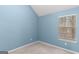 Bright blue bedroom with carpet and natural light streaming through the window at 704 Davenport Ct, Stockbridge, GA 30281