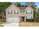 Charming two-story home featuring a two car garage, neutral siding and dark shutters at 704 Davenport Ct, Stockbridge, GA 30281