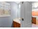 Neat powder room featuring a wood vanity, sink, and bright natural light from the window at 704 Davenport Ct, Stockbridge, GA 30281