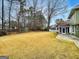 Expansive backyard showcasing a large lawn, landscaping and a storage shed at 642 Grecken Grn, Peachtree City, GA 30269