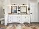 Bright bathroom featuring a double vanity, dark fixtures, tile floor, and a separate toilet room at 642 Grecken Grn, Peachtree City, GA 30269