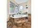 Bathroom featuring a soaking tub with tile surround and corner windows at 642 Grecken Grn, Peachtree City, GA 30269