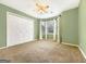 Bedroom featuring olive green walls, carpet, a closet, and a bank of windows at 642 Grecken Grn, Peachtree City, GA 30269