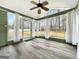 Bright sunroom with many windows, curtains, ceiling fan, and wood-look flooring at 642 Grecken Grn, Peachtree City, GA 30269