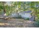Home's back exterior featuring a wooden deck and stairs surrounded by mature trees at 4226 Highway 155 N, Stockbridge, GA 30281