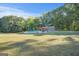 Spacious backyard featuring a swimming pool, pergola, and dining set, surrounded by a verdant lawn and mature trees at 4226 Highway 155 N, Stockbridge, GA 30281