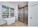Bathroom with freestanding tub, tiled shower, and a window overlooking the outdoors at 271 Trestle Rd, Locust Grove, GA 30248