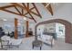 Open-concept living room featuring exposed beams, a brick archway, and lots of natural light at 271 Trestle Rd, Locust Grove, GA 30248