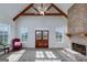 Cozy living room with brick fireplace, wood-look flooring, and a vaulted ceiling with exposed beams at 271 Trestle Rd, Locust Grove, GA 30248
