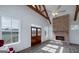 Bright living room featuring vaulted ceiling, exposed beams, brick fireplace and large picture windows at 271 Trestle Rd, Locust Grove, GA 30248