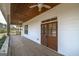 Wide covered porch with wood decking, ceiling fans, and double doors to the interior at 271 Trestle Rd, Locust Grove, GA 30248
