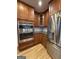 Close up of stainless steel oven and refrigerator with granite countertops and wooden cabinets at 2577 Headland Dr, East Point, GA 30344