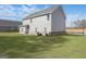 Back exterior view showing a spacious backyard with lush green grass and neutral-colored siding at 3735 Saddle Bag Ct, Dacula, GA 30019