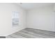 Bright bedroom featuring a window with blinds, neutral paint, and modern gray wood-look flooring at 3735 Saddle Bag Ct, Dacula, GA 30019