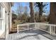 Enjoy outdoor living on the backyard deck with a white railing and a beautiful view of the mature trees at 3822 Holland Dr, Snellville, GA 30039