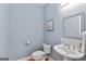 Powder room featuring blue walls, pedestal sink, and toilet at 6275 Glen Oaks Ln, Atlanta, GA 30328