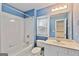 Bathroom features blue walls, white fixtures, and shower-tub combination at 6275 Glen Oaks Ln, Atlanta, GA 30328