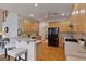 Spacious kitchen with breakfast bar, wood cabinets, and hardwood floors, adjacent to stairs at 6275 Glen Oaks Ln, Atlanta, GA 30328