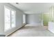 Bright living room featuring carpet flooring, large windows, and neutral paint at 1408 Fairfield Sw Dr, Lilburn, GA 30047