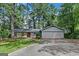 Single Gathering home featuring a stone and siding exterior, two-car garage, and mature landscaping at 1408 Fairfield Sw Dr, Lilburn, GA 30047