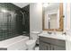 Updated bathroom featuring dark tile in the shower, white vanity and floors at 1408 Fairfield Sw Dr, Lilburn, GA 30047
