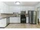 Modern kitchen with stainless steel refrigerator, dishwasher, and a black oven at 1408 Fairfield Sw Dr, Lilburn, GA 30047
