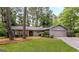 Ranch-style home with a stone accent, gray siding, well-kept lawn, and mature trees at 1408 Fairfield Sw Dr, Lilburn, GA 30047