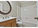 Clean bathroom featuring a vanity, round mirror, toilet, and tiled shower-tub combination at 618 Grecken Green, Peachtree City, GA 30269