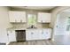 Well-lit kitchen featuring white cabinetry, stainless steel appliances, and hardwood flooring at 3824 Charlotte Dr, Rex, GA 30273