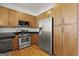 Modern kitchen with stainless steel appliances, wood cabinets, and ample counter space at 978 N Avenue Ne 307, Atlanta, GA 30306