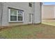 View of the backyard featuring a grassy area, the back of the house, a door and a large window at 4607 Ravenwood Loop, Union City, GA 30291