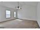 Spacious bedroom featuring neutral carpet, a ceiling fan, and abundant natural light from two windows at 4607 Ravenwood Loop, Union City, GA 30291