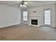 Spacious living room with a fireplace, large windows, and a door leading to the backyard at 4607 Ravenwood Loop, Union City, GA 30291