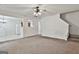 Open living room view showing stairs, a ceiling fan, and a glimpse of the kitchen at 4607 Ravenwood Loop, Union City, GA 30291