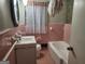 Retro bathroom with a pink tile scheme, featuring a sink, toilet, tub, and shower at 5535 Beaver Sw Dr, Mableton, GA 30126