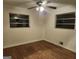 Clean bedroom featuring hardwood flooring, two windows, and a ceiling fan at 5535 Beaver Sw Dr, Mableton, GA 30126
