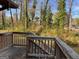 View of the backyard and surrounding trees from the wooden deck with railings at 1725 Sara Se Ct, Conyers, GA 30013