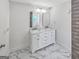Contemporary bathroom with double sink vanity, marble countertop and backsplash, and tile flooring at 2117 Keheley Dr, Decatur, GA 30032