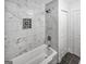 Well-lit bathroom with a modern tub and marble tile surround with decorative niche at 2117 Keheley Dr, Decatur, GA 30032