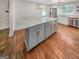 Modern kitchen island with white marble countertop and light gray cabinets on dark hardwood floors at 2117 Keheley Dr, Decatur, GA 30032