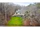 Wide shot of a yellow house on a lush green lawn with a fenced yard and mature trees at 160 Allie Dr, Mcdonough, GA 30252