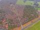 Aerial view of wooded property with long driveway, pasture, and road at 630 Stoney Point Rd, Bowdon, GA 30108