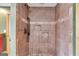 Walk-in shower featuring brown tile, a shower head, and two built-in shelves at 630 Stoney Point Rd, Bowdon, GA 30108