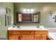 Bathroom with a dual sink vanity with a large framed mirror and a bathtub at 630 Stoney Point Rd, Bowdon, GA 30108