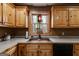 Kitchen with wooden cabinets, stained-glass window above the sink, and neutral countertops at 630 Stoney Point Rd, Bowdon, GA 30108