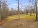 A beautiful meadow leads to a rustic home tucked among the trees, offering peace and seclusion at 630 Stoney Point Rd, Bowdon, GA 30108