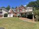 Charming brick home featuring a manicured lawn on a sunny day at 4043 Windgrove Xing, Suwanee, GA 30024