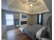 Main bedroom featuring a tray ceiling, fireplace, mounted television, and natural light at 4043 Windgrove Xing, Suwanee, GA 30024