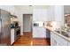 Well-lit kitchen showcasing white cabinets, granite countertops, stainless steel appliances, and hardwood floors at 150 Valley Bluff Dr, Fayetteville, GA 30215